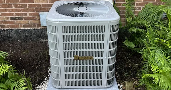 Ducane air conditioner condenser installed beside a brick home