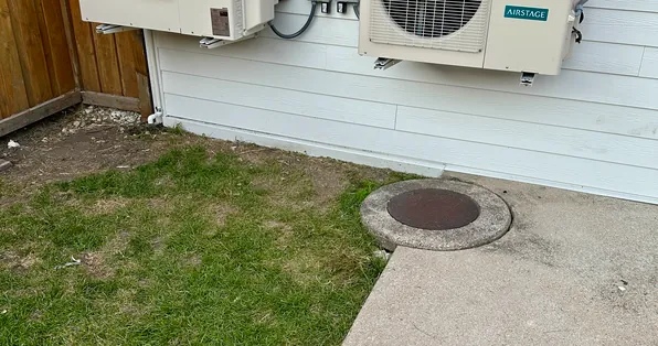 Fujitsu mini-split outdoor units mounted on the siding of a home