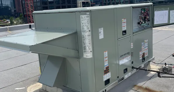 Packaged rooftop heating and cooling unit with the Chicago skyline behind it